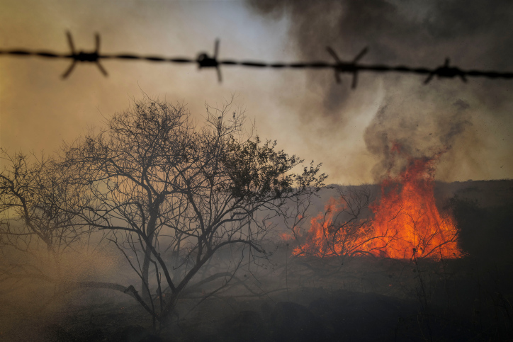 Israeli firefighters and civilians try to extinguish a fire which broke out from missiles and drones fired from Lebanon, at the Ein Kshatot National Heritage Site in Moshav Natur, Moshav Aniam , Golan Heights on July 4, 2024. Photo by Michael Giladi/ Flash90