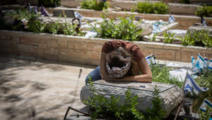 Anat Meir mourns at the grave of her husband, Sayeret Matkal soldier David Meir, who was killed by Hamas terrorists during the Battle of Kibbutz Be'eri on October 7, at Mount Herzl Military Cemetery in Jerusalem on July 9, 2024. Photo by Chaim Goldberg/Flash90.