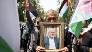 Iranians carry the portrait of slain Hamas leader Ismail Haniyeh and wave Palestinian flags during a protest rally at Tehran University in Tehran, Iran, July 31, 2024. Photo: EPA-EFE/ABEDIN TAHERKENAREH