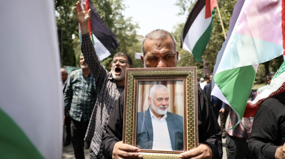 Iranians carry the portrait of slain Hamas leader Ismail Haniyeh and wave Palestinian flags during a protest rally at Tehran University in Tehran, Iran, July 31, 2024. Photo: EPA-EFE/ABEDIN TAHERKENAREH