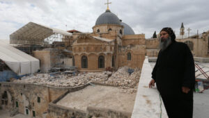 A Coptic priest looks at the Church of the Holy Sepulchre in the Old City of Jerusalem. Photo by Nati Shohat/Flash90.