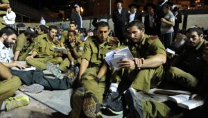 IDF soldiers sit on the ground during Tisha B'Av prayers at the Western Wall in the Old City of Jerusalem, July 16, 2013. Photo by Mendy Hechtman/Flash90.