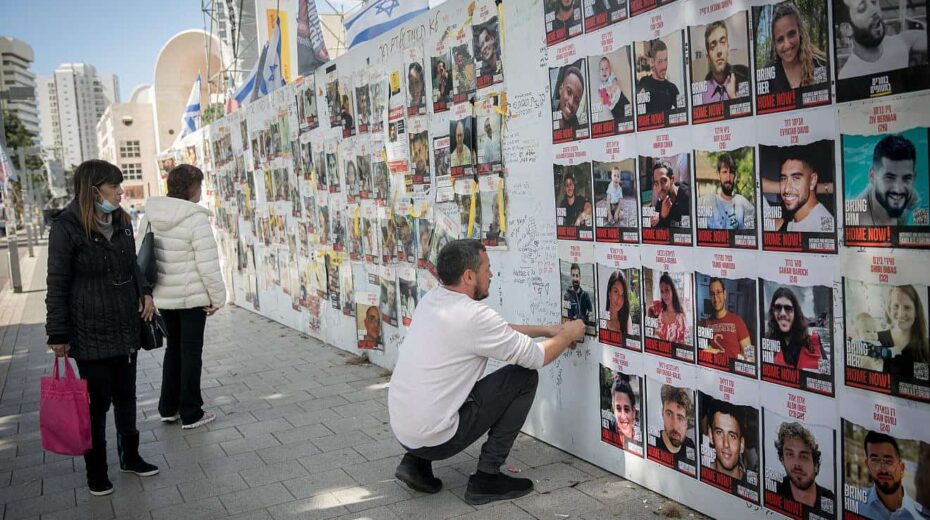 A man posts photographs of the Israelis still being held captive in the Gaza Strip by Hamas terrorists at "Hostages Square" in Tel Aviv on March 4, 2024. Photo by Miriam Alster/Flash90.