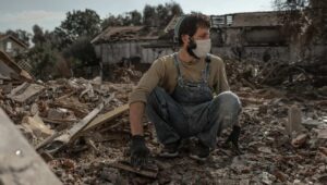 A man whose father was murdered by Hamas terrorists on Oct. 7 searches the rubble of his home for family mementos in Kibbutz Be'eri, Nov. 30, 2023. Photo by Chen Schimmel/Flash90.