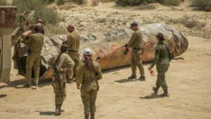 Israeli soldiers remove the remains of a missile fired from Iran, near the southern Israeli city of Arad, May 2, 2024. Photo by Erik Marmor/Flash90