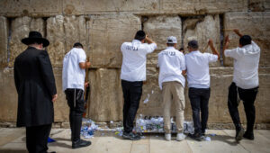 Workers remove handwritten notes from between the ancient stones of the Western Wall in the Old City of Jerusalem. This action takes place twice a year, before Passover and on the Jewish New Year. Photo by Yonatan Sindel/Flash90