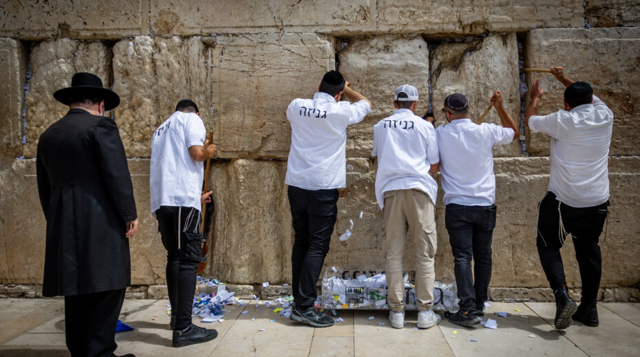 Workers remove handwritten notes from between the ancient stones of the Western Wall in the Old City of Jerusalem. This action takes place twice a year, before Passover and on the Jewish New Year. Photo by Yonatan Sindel/Flash90
