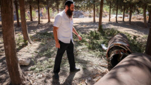 A religious Jewish man examines the remains of an Iranian ballistic missile in northern Israel. Photo by David Cohen/Flash90