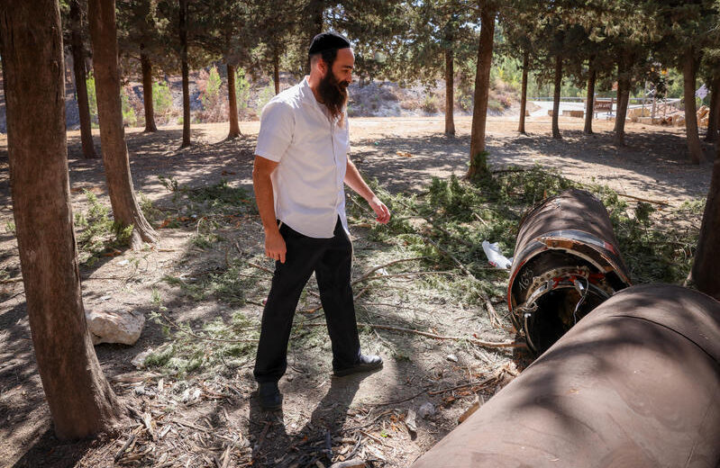 A religious Jewish man examines the remains of an Iranian ballistic missile in northern Israel. Photo by David Cohen/Flash90