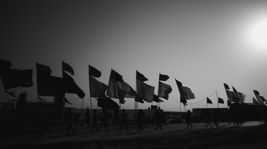 Shiites with flags on the way to the city of Karbala as part of the ritual visit to the memorial of Imam Hussein bin Ali. Photo: Shutterstock.