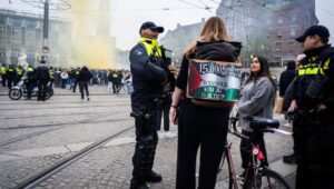 Dutch police officers speak with a pro-Palestinian activist as fans of Maccabi Tel Aviv gather before the UEFA Europa League match against Ajax in Amsterdam, on November 7, 2024. EPA-EFE/JEROEN JUMELET