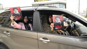 As the Lebanon ceasefire comes into effect, people in Beirut celebrate "victory" by waving Hezbollah flags and holding photos of the terror group's slain leader, Hassan Nasrallah. Photo by EPA-EFE/WAEL HAMZEH