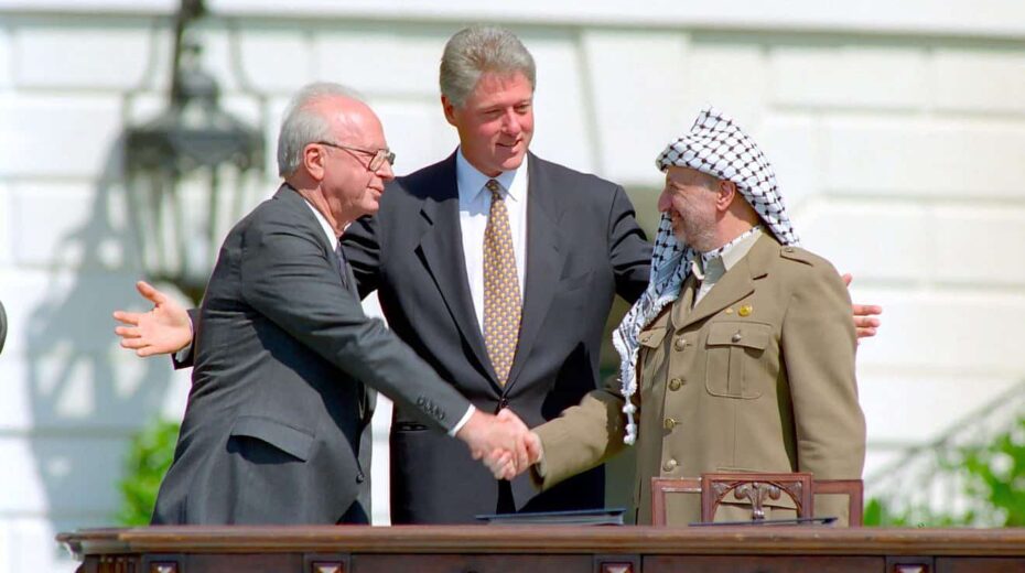 US President Bill Clinton looks on as Israeli Prime Minister Yitzhak Rabin and PLO head Yasser Arafat shake hands at the signing of the Oslo Accords on Sept. 13, 1993. Credit: William J. Clinton Presidential Library/National Archives & Records Administration.