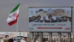 An Iranian flag flies in front of a poster depicting (from right to left) slain Hezbollah commander Fouad Shukur, slain Hamas leader Yahya Sinwar, slain Hezbollah leader Hassan Nasrallah, slain Hamas leader Ismail Haniyeh, slain Hezbollah Executive Council member Hashem Safieddine and slain Hamas leader Saleh al-Arouri, during a rally in Sanaa, Yemen, on November 1, 2024. Their addiction to destroying Israel cost them their lives. Photo: EPA-EFE/YAHYA ARHAB