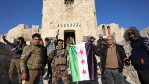 Opposition fighters and locals pose with a Syrian flag in Aleppo, Syria, November 30, 2024, after a major rebel offensive on November 27 that captured large parts of the country's second-largest city. Photo: EPA-EFE/Mohammed Al-Rifai