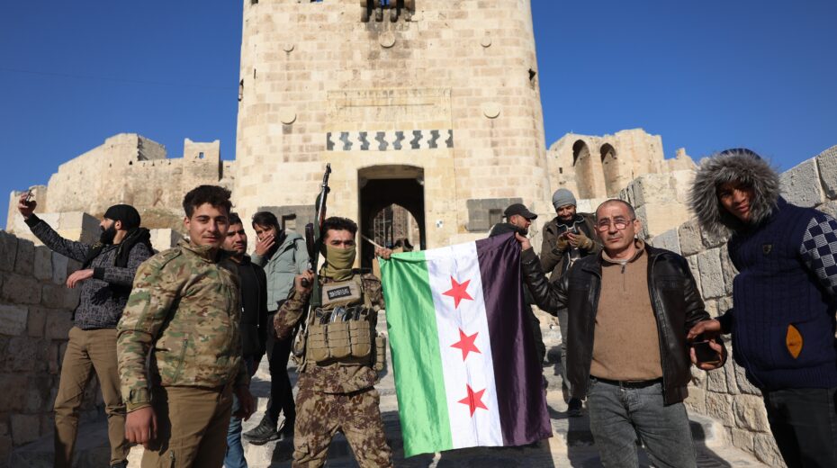 Opposition fighters and locals pose with a Syrian flag in Aleppo, Syria, November 30, 2024, after a major rebel offensive on November 27 that captured large parts of the country's second-largest city. Photo: EPA-EFE/Mohammed Al-Rifai