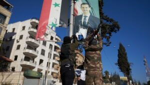 Syrian rebels tear up a portrait of Syrian President Bashar al-Assad in central Aleppo, Syria, November 30, 2024. Photo: EPA-EFE/KARAM AL-MASRI