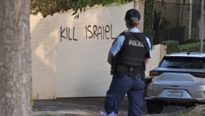 A policewoman stands next to anti-Israel graffiti in Sydney, Australia, December 11, 2024. Photo: EPA-EFE/MICK TSIKAS