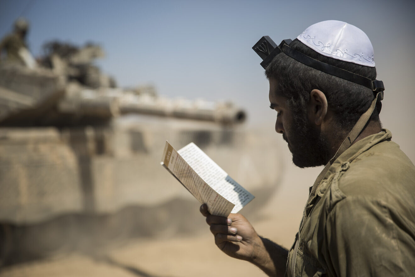 An Israeli soldier prays in an IDF staging area near the border with Gaza, July 27, 2014. Photo by Hadas Parush/Flash90.