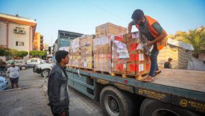 Palestinians unload aid from a truck in the Gaza Strip. Photo by Atia Mohammed/Flash90