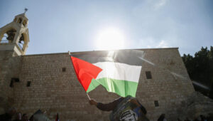 A Palestinian flag is waved outside the Church of the Nativity in Bethlehem. Photo by Wisam Hashlamoun/Flash90