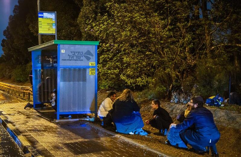 Israelis take cover on the side of a highway as a ballistic missile from Yemen is intercepted overhead, on the night of December 30, 2024. Photo by Yossi Aloni/Flash90
