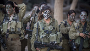 Soldiers of the IDF's mixed gender Caracal Infantry Battalion prepare for a 9.5-mile overnight hike to complete their training course, near the border with Egypt, Sept. 3, 2014. Photo by Hadas Parush/Flash90.
