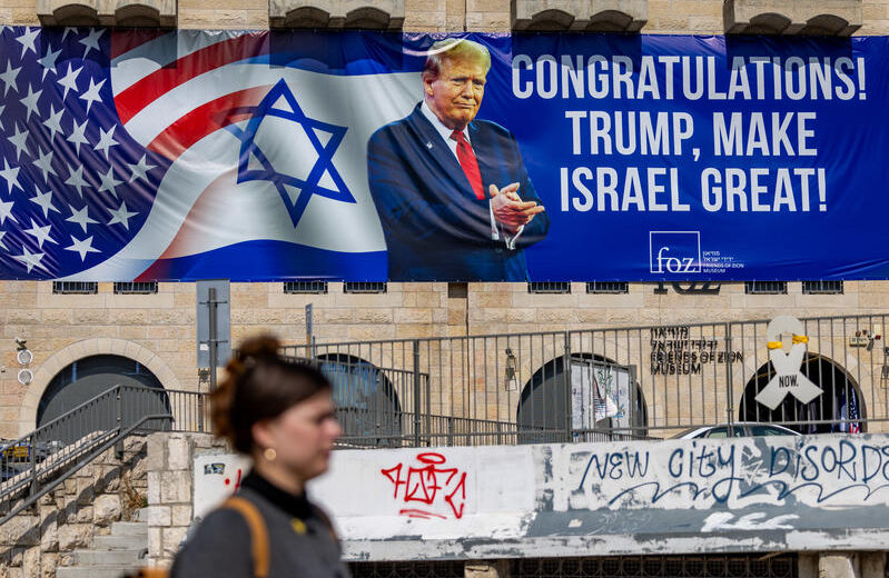 People walk next to a sign congratulating U.S. President Donald Trump for his victory in the US presidential election in central Jerusalem, November 7, 2024. Photo by Yonatan Sindel/Flash90