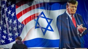 Pepole walk next to a sign congratulating U.S. President Donald Trump for his victory in the US presidential election, in central Jerusalem, January 20, 2025. Photo by Yonatan Sindel/Flash90