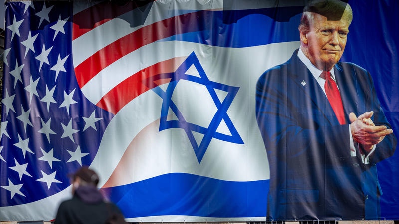 Pepole walk next to a sign congratulating U.S. President Donald Trump for his victory in the US presidential election, in central Jerusalem, January 20, 2025. Photo by Yonatan Sindel/Flash90