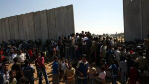 Palestinians (foreground) are blocked by Egyptian police after Palestinian terrorists exploded a part of the border wall in the southern Gaza Strip city of Rafah, June 29, 2006. Photo by Ahmad Khateib/Flash90.