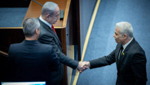 Israeli Prime Minister Benjamin Netanyahu shake hands with Opposition Leader Yair Lapid at a plenum session for Israeli Knesset's 75th birthday, in the assembly hall of the Knesset, the Israeli parliament in Jerusalem, Israel on Jan, 24, 2024. Photo by Yonatan Sindel/Flash90.
