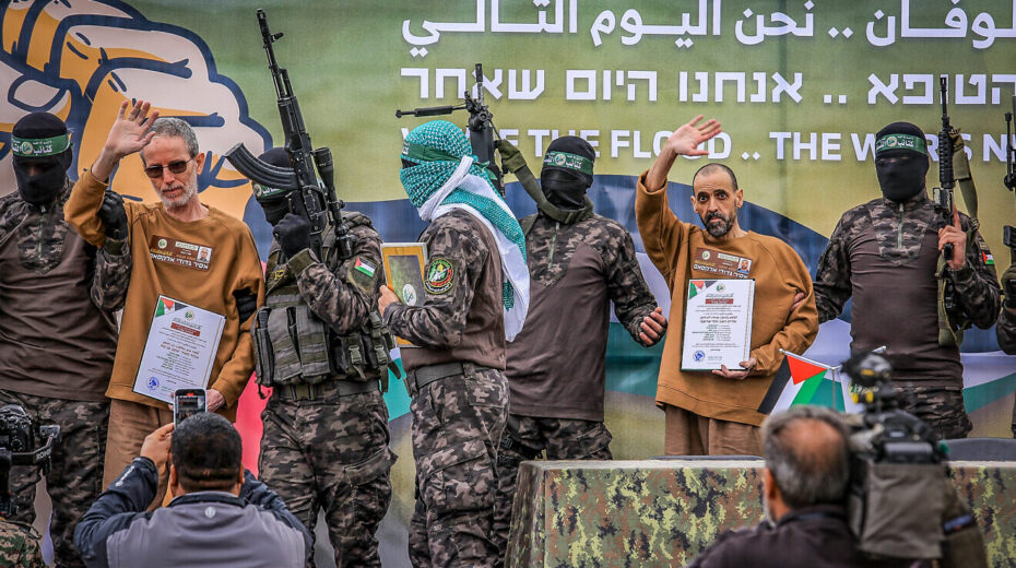 Hamas terrorists in its Al-Qassam Brigades parade Israeli hostages Eli Sharabi (right), Or Levy and Ohad Ben Ami (left) on a stage before handing them over to the International Red Cross, Feb 8, 2025. Photo by Abed Rahim Khatib/Flash90.