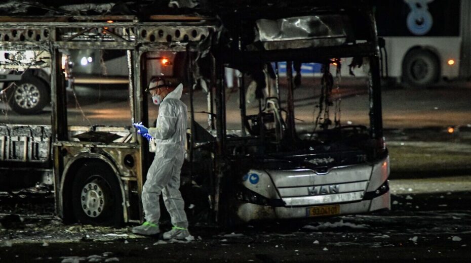 An investigator examines a bombed bus in Bat Yam, south of Tel Aviv, Feb. 20, 2025. Credit: Flash90.