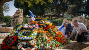 Mourners near the fresh grave of late Israeli hostages Shiri Bibas and her children Ariel and Kfir at the cemetery in Tzohar, southern Israel, Feb. 26, 2025. Photo by Chaim Goldberg/Flash90.