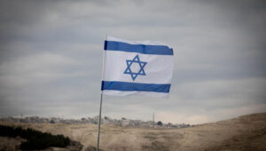 An Israeli flag planted on a hilltop in the biblical heartland, just east of Jerusalem. Photo by Yonatan Sindel/Flash90