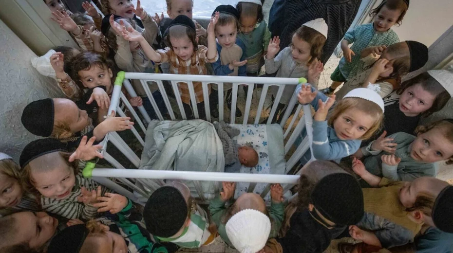 Boys in Jerusalem's ultra-Orthodox neighborhood of Mea She'arim recite the Shema Yisrael prayer in the presence of a week-old baby, one day before his circumcision ceremony on July 9, 2023. Photo by Chaim Goldberg/Flash90.