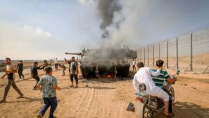 Palestinians take control of an Israeli tank after invading through the border fence from Khan Yunis in the southern Gaza Strip, Oct. 7, 2023. Photo by Abed Rahim Khatib/Flash90.