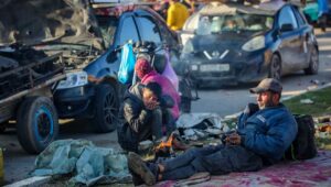 Palestinians wait on Salah al-Din Road, the main highway of the Gaza Strip, not far from the Netzarim Corridor that separates the north of the Gaza Strip from the south, Jan. 26, 2025. Photo by Ali Hassan/Flash90.