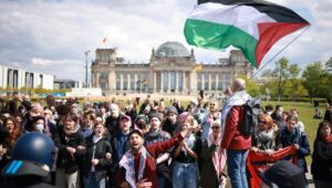 A demonstrator waves a Palestinian flag as police attempt to disperse a pro-Palestine protest camp in front of the Reichstag building in Berlin, Germany, on April 26, 2024. Photo: EPA-EFE/CLEMENS BILAN