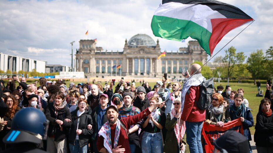 A demonstrator waves a Palestinian flag as police attempt to disperse a pro-Palestine protest camp in front of the Reichstag building in Berlin, Germany, on April 26, 2024. Photo: EPA-EFE/CLEMENS BILAN