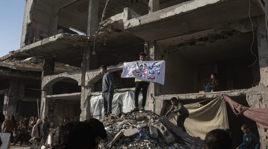 A boy holds a banner reading "Enough destroyed, enough killed, we want to live" during a demonstration in Beit Lahia in the northern Gaza Strip. Photo: EPA-EFE/HAITHAM IMAD