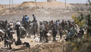 Palestinians carry humanitarian aid received from the US-backed Gaza Humanitarian Foundation as they walk through the so-called Netzarim Corridor in the center of the Gaza Strip, May 29, 2025. Photo: EPA-EFE/HAITHAM IMAD