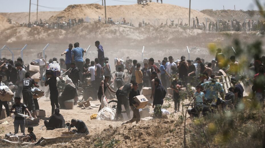 Palestinians carry humanitarian aid received from the US-backed Gaza Humanitarian Foundation as they walk through the so-called Netzarim Corridor in the center of the Gaza Strip, May 29, 2025. Photo: EPA-EFE/HAITHAM IMAD