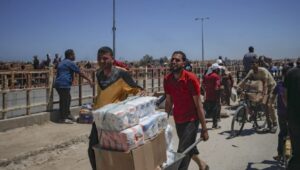 Palestinians transport humanitarian aid received from the US-backed Gaza Humanitarian Foundation through an area known as the Netzarim Corridor in the central Gaza Strip, May 29, 2025. Photo: EPA-EFE/HAITHAM IMAD