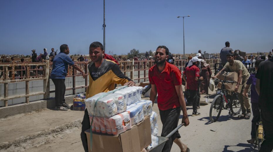 Palestinians transport humanitarian aid received from the US-backed Gaza Humanitarian Foundation through an area known as the Netzarim Corridor in the central Gaza Strip, May 29, 2025. Photo: EPA-EFE/HAITHAM IMAD