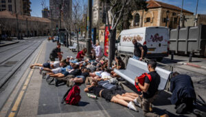Young people try to protect themselves on Jaffa Street in Jerusalem. Photo: Chaim Goldberg/Flash90