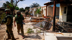 Israeli soldiers clear the destruction caused by Hamas militants in Kibbutz Kfar Aza near the Israeli-Palestinian border in southern Israel, October 10, 2023. Photo by Chaim Goldberg/Flash90