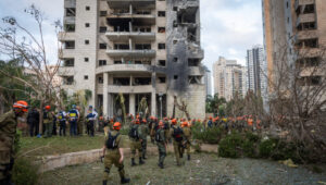Israeli security and rescue forces at the site where an Iranian-fired ballistic missile struck and caused damage in Petah Tikva on June 16, 2025. Photo: Chaim Goldberg/Flash90