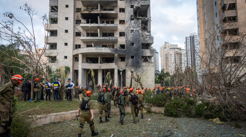 Israeli security and rescue forces at the site where an Iranian-fired ballistic missile struck and caused damage in Petah Tikva on June 16, 2025. Photo: Chaim Goldberg/Flash90